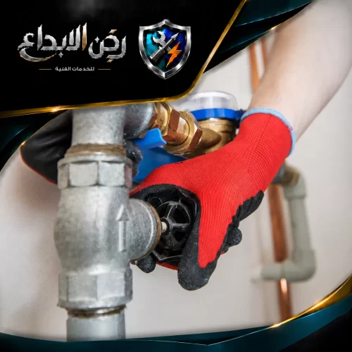 يد ترتدي قفازًا واقيًا تقم بإحكام إغلاق محبس رئيسي للتحكم بـ شبكة المياه وضمان سلامة التمديدات المنزلية.