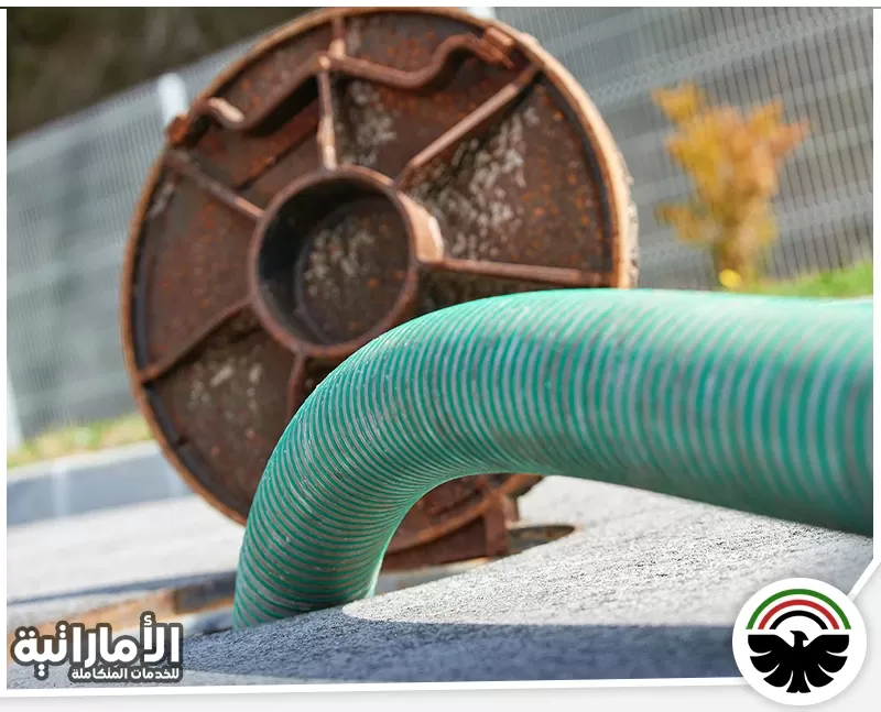 اسيد تسليك المجاري في ابوظبي 0553689103 ركن الابداع خرطوم شفط مجاري كبير متصل بفتحة صرف مع غطاء معدني مفتوح أثناء تنفيذ خدمة الشفط.