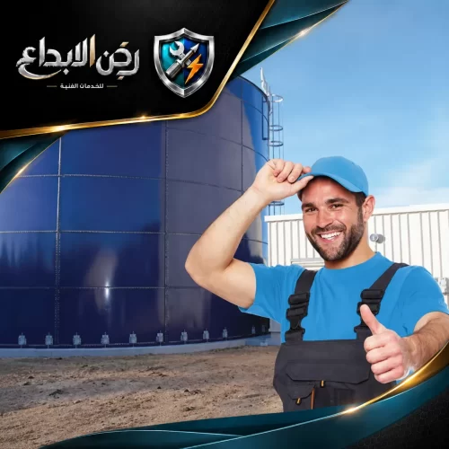 فني صيانة يرتدي أفرول أزرق وقبعة أمام خزان مياه صناعي عملاق، دلالة على إتمام صيانة خزانات ناجحة.