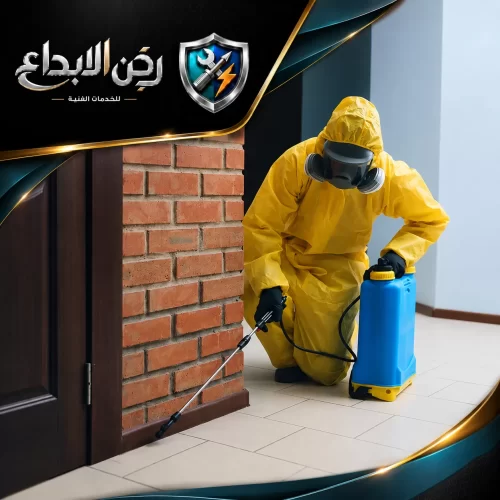 مكافحة النمل الأبيض راس الخيمة 0553689103 ركن الابداع فني يرتدي بدلة واقية صفراء وقناعاً كاملاً لرش المبيدات بحذر على حواف الجدران لضمان القضاء على الحشرات